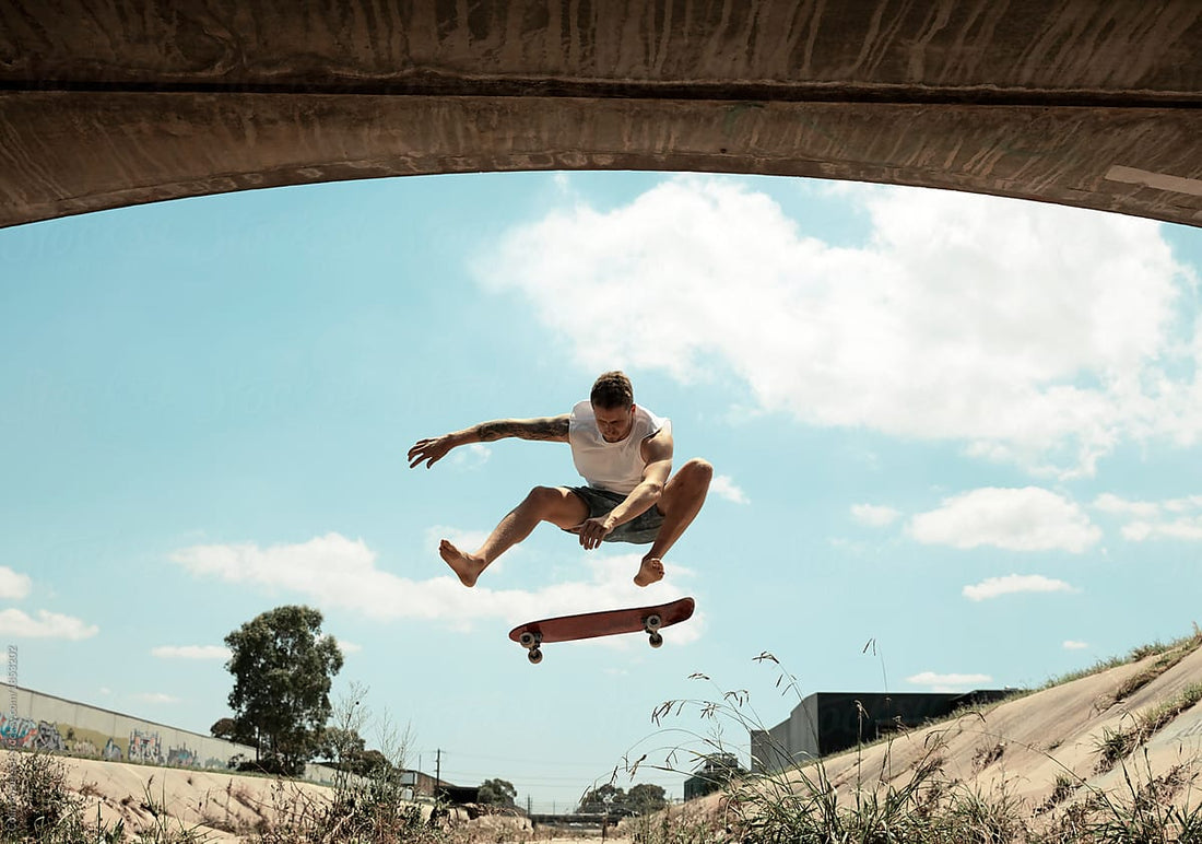 Man on a skate park performs a skateboard trick